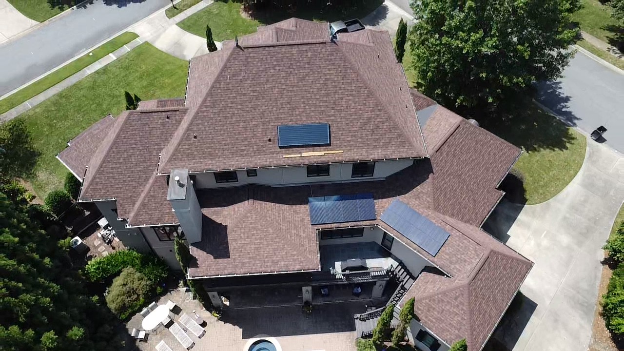 Aerial view of a completed 105-square Owens Corning Duration Brownwood roof coordinated with solar features